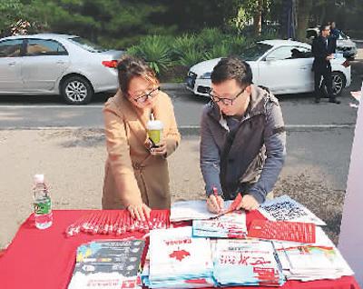 萧尧在海外院校招生面试会的校园路演活动中，为学生家长做咨询。