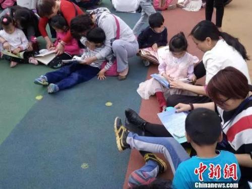 资料图:一家幼儿园内,师生、家长共同和孩子阅读 杨大勇 摄