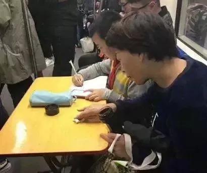 在上海地铁上写作业的母子