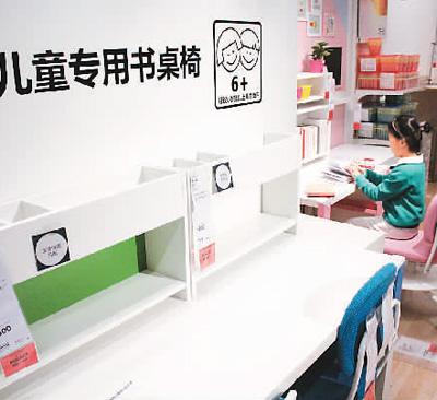 在江苏无锡,小朋友在体验儿童专用书桌椅。资料图片