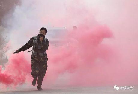 生化演习环节，一位带队老师用水蘸湿的帽子捂住嘴，从浓烟中跑过。