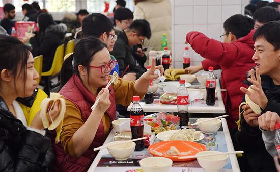联谊会上,同学开心地吃着饺子。