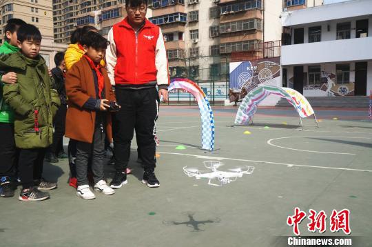 图为小学生在教练的指导下进行无人机实操飞行体验。　韩章云 摄