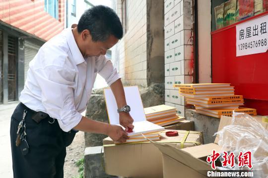 图为余太湖在书上盖团队的捐赠章。瞿宏伦摄