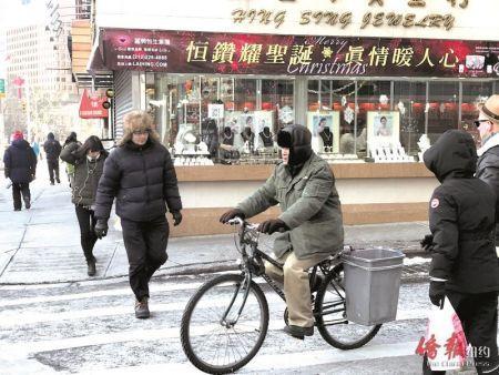 天寒地冻，华人外卖郎的身影出现在华埠街头。（美国《侨报》陈辰摄）