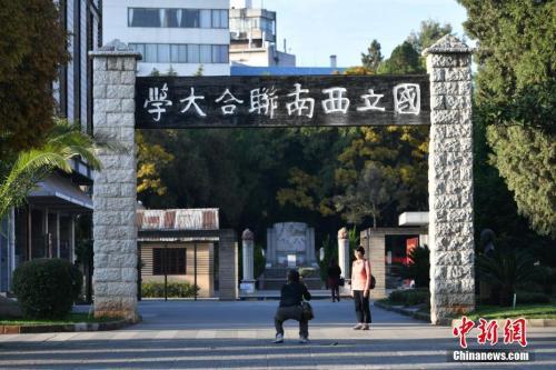 资料图：2017年11月1日，游客在西南联大旧址前留影。当日，正值西南联合大学建校80周年纪念日。中新社记者 任东 摄