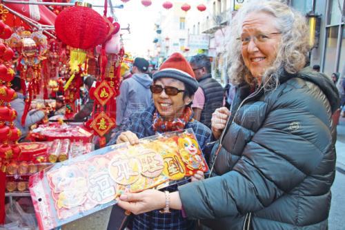 许多非华裔的民众也在选购年货,拿着“福来旺到”的春联。(美国《世界日报》记者李晗/摄影)