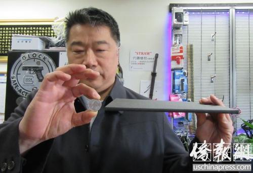 枪支店主展示一片又轻又薄的防弹板。(美国《侨报》记者翁羽摄)