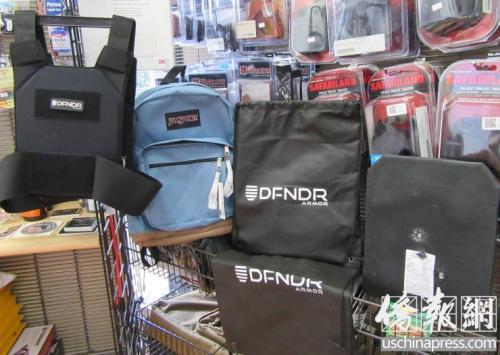 亚凯迪亚市枪店内的防弹背心、可放置防弹板的背包,以及做过枪击实验的防弹板。(吗,美国《侨报》记者翁羽摄)