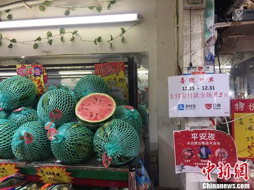  某水果店内悬挂的支付宝宣传标语，写着“支付宝付款全场9.5折”。 中新网 王佳昕 摄