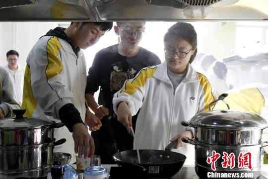 图为青海师范大学附属中学厨艺课，几位同学正在尝试炒菜。　张海雯 摄