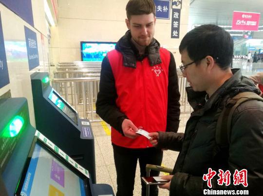 一名白俄罗斯留学生帮助乘客取高铁票。　刘鹏 摄