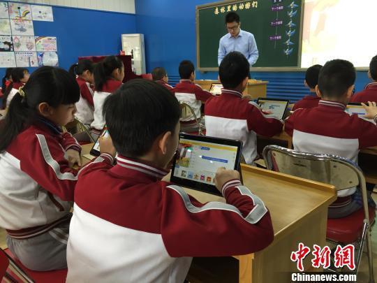 小学生在老师指导下进行编程操作 郑嘉伟 摄