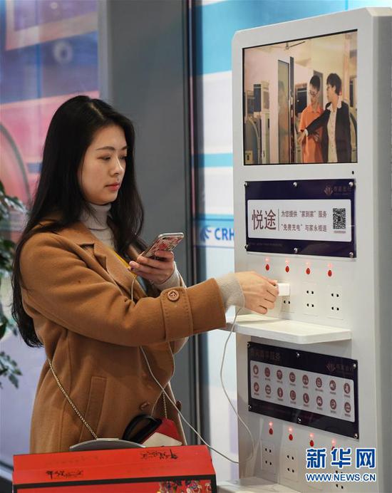 2月11日，阳知涵在重庆沙坪坝站候车厅给手机充电。