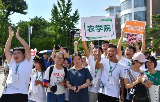 中国农业大学东区体育馆操场，迎新的学长们热情地向新生打招呼。