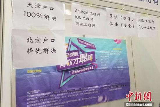 4月12日,北京某高校内的毕业生双选会上,一家企业贴出了解决户口的告示。 冷昊阳 图
