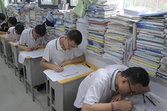 高三学生在教室内参加高考模拟考试，教室窗台上摆满了各种复习资料。 视觉中国 资料图