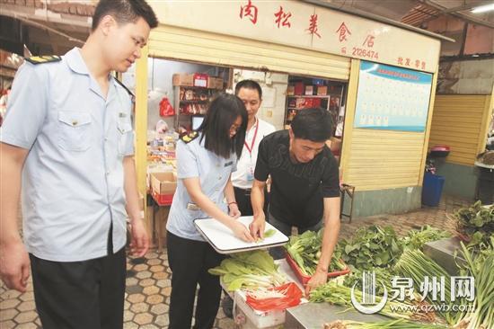 在菜市场，家长参与蔬菜抽样检测。