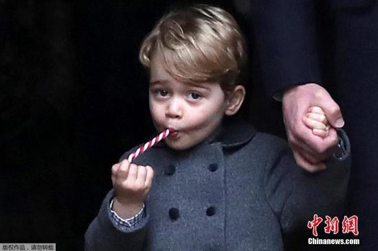 资料图：乔治王子吃着棒棒糖亮相。
