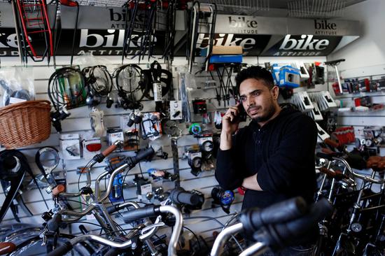 当地时间2018年5月3日，丹麦哥本哈根，来自巴基斯坦的John Khan在在他的自行车店里打电话。John Khan是Mjolnerparken社区的居民。