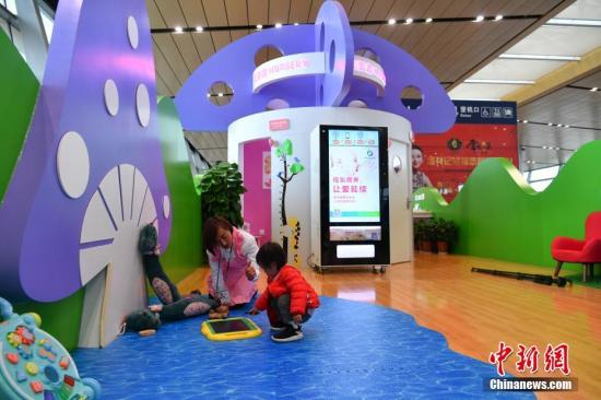 资料图:一位母亲陪孩子玩耍。中新社记者 任东 摄