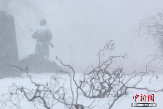 资料图：当地时间2018年1月4日，暴雪中纽约法拉盛公园中的雕塑。当日，纽约降下2018年首场暴雪。受一波被称为“炸弹气旋”的风暴影响，美国东北部地区当天普遍遭受暴雪袭扰，3000多个航班因此取消。 中新社记者 廖攀 摄