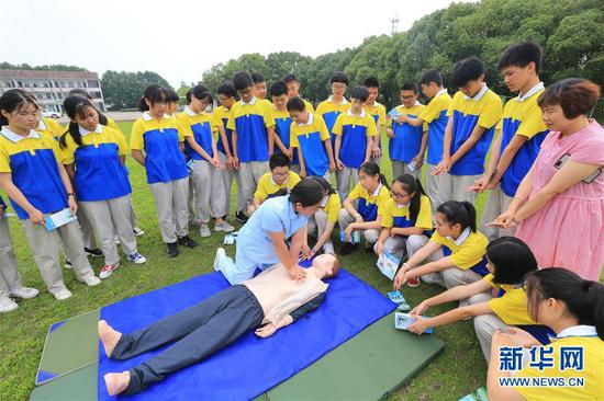 7月4日，浙江省德清县新安镇下舍中心学校的学生在专业救护人员的指导下学习急救知识。 暑期来临，各地学校纷纷组织学生开展暑期安全教育主题活动，让孩子们度过一个安全快乐的假期。 新华社发（姚海翔 摄）