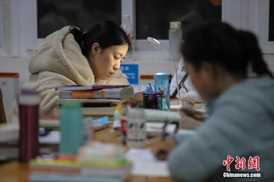 11月25日，贵州民族大学逸夫图书馆内，考研学生正在看书复习，为2020年全国硕士研究生招生考试做准备。 中新社记者 瞿宏伦 摄