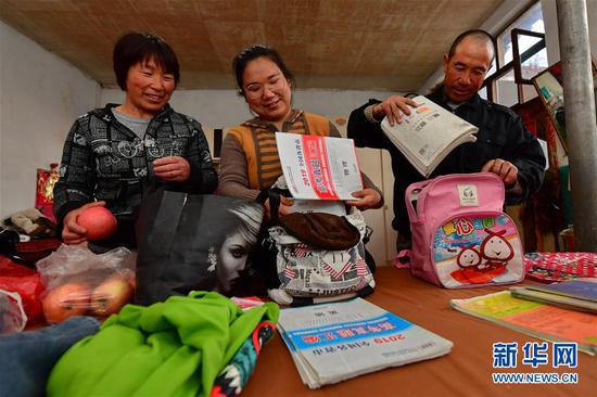 李彦昀（中）和父母在静乐县新开岭村的家中收拾返校行李（3月24日摄）。 新华社记者 曹阳 摄