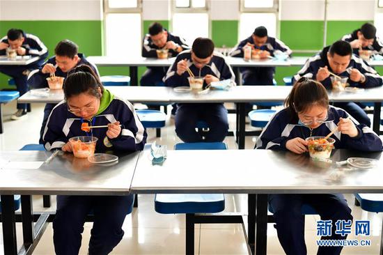 李彦昀（前左）在山西省静乐县第一中学食堂吃饭（3月25日摄）。 新华社记者 曹阳 摄