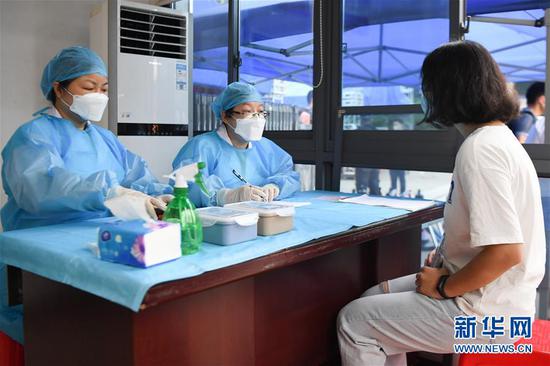 7月3日,医务人员在体温复核区模拟询问考生(右)身体情况。 新华社记者 薛宇舸 摄