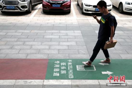 资料图：西安街头出现一条专为“低头族”设计的通道。中新社记者 张远 摄