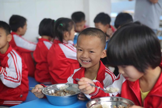 图为孩子们在希望厨房里愉快地就餐。