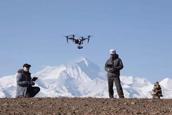 无人机驾驶员郑国强和张晶在珠穆朗玛峰拍摄纪录片时的工作场景。