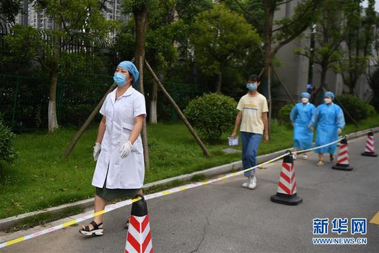 7月3日,医务人员(左一)模拟带领发热考生(中)从隔离考室专用通道进入隔离备用考室。 新华社记者 薛宇舸 摄