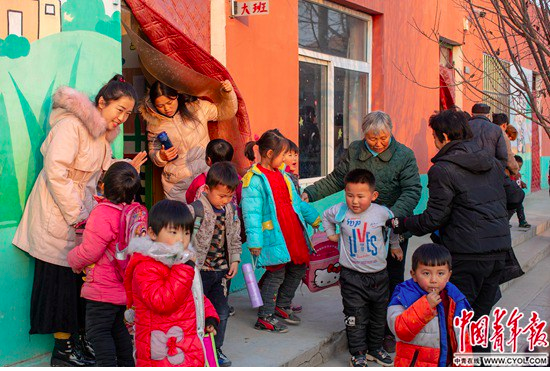 12月13日，大名县营镇乡赵庄村幼儿园，家长到教室外接孩子们回家。