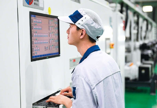 在位于浙江省绍兴市越城区的绍兴三花新能源汽车部件产业园,员工操纵智能零部件真空焊接设备(2022 年 8 月 2 日摄) 翁忻旸摄 / 本刊