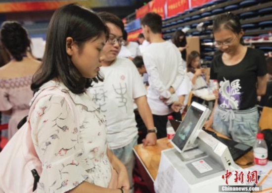 　　8月30日，3000余名2018级新生来北京大学报到，开启大学生活。据悉，今年北大启动了数字迎新平台，通过“刷脸”和身份证验证就可以识别新生信息，简化了报到流程。图为一名新生“刷脸”报到。中新社记者 贾天勇 摄