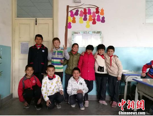 刘春韦联系以前的同事朋友,为孩子们募集了4箱新衣服和一大箱文具。图为穿着新衣服的学生们。 刘春韦供图 摄