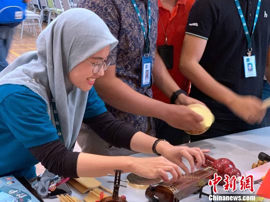 现场迷你版中国乐器吸引世纪大学学生体验。　陈悦 摄