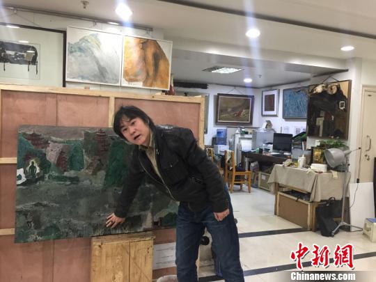 图为西北民族大学美术学院教授刘志刚展示自己的漆画作品《丝路古风》。　崔琳　摄