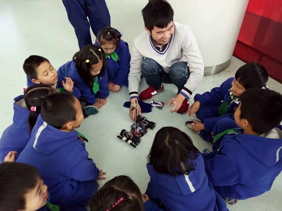 志愿者为“儿童大学”的孩子们讲解智能汽车 来源/上海海事大学