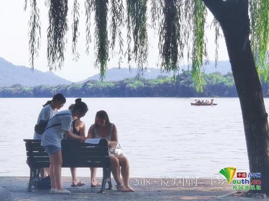 游客和成员们与西湖美景形成了一幅画。中国青年网通讯员 王丽慧 摄