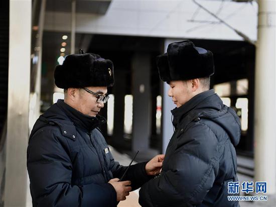 1月16日，李海云（左）为儿子李诚整理着装。新华社发（张龙 摄）