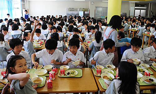 资料图：在日本首都东京学艺大学附属小金井小学食堂，学生在用餐。（新华社）