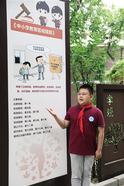 2021年5月26日，北京十八中附小法治展板前，学生法治宣讲团成员进行有关《中小学教育惩戒规则》的宣讲。新京报记者 王远征 摄