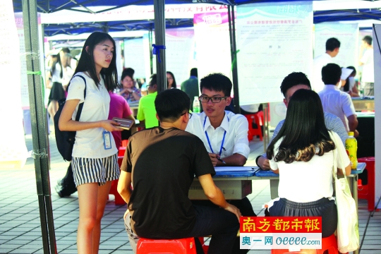 11月18日，陈良岸(右)在广东科技学院招聘会上设点招聘员工。
