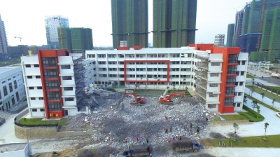 1月4日下午，广西南宁天桃实验学校荣和校区，两台大型破拆机械在拆除教学楼。图/东方IC