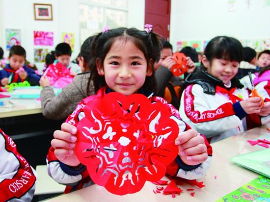 学生体验剪纸。 资料配图