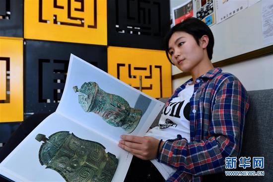 5月3日，有维娜在翻阅青铜器图书以获得设计灵感。新华社记者 郭绪雷摄